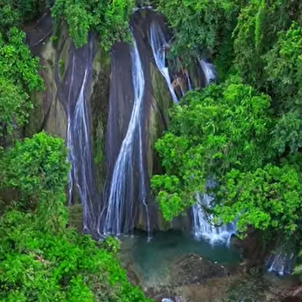 A stunning view of Bingkayan Waterfalls in Surigao del Sur, showcasing the cascading water surrounded by lush, vibrant greenery.